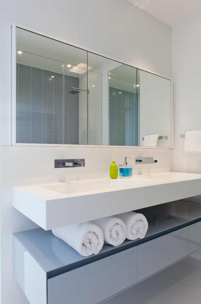 Идея дизайна: ванная комната в современном стиле с плоскими фасадами, белыми фасадами, белыми стенами и монолитной раковиной