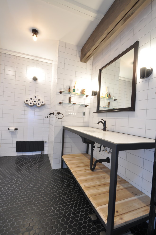 Photo of a medium sized urban ensuite bathroom in New York with open cabinets, light wood cabinets, a walk-in shower, a one-piece toilet, white tiles, white walls, ceramic flooring, granite worktops, an integrated sink, metro tiles and black floors.