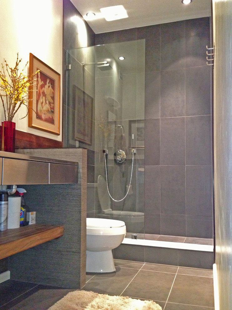 Inredning av ett modernt mellanstort badrum med dusch, med en öppen dusch, grå kakel, beige väggar, klinkergolv i terrakotta, ett integrerad handfat, bänkskiva i rostfritt stål, möbel-liknande, skåp i mellenmörkt trä, en toalettstol med hel cisternkåpa och stenkakel