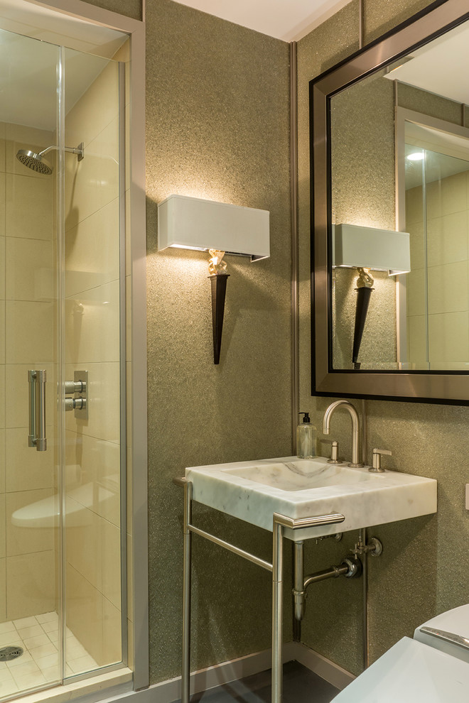 Modern inredning av ett litet badrum med dusch, med ett piedestal handfat, öppna hyllor, vita skåp, marmorbänkskiva, en dusch i en alkov, en toalettstol med hel cisternkåpa, grå kakel, cementkakel och betonggolv