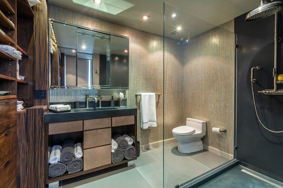 Exempel på ett mellanstort industriellt en-suite badrum, med släta luckor, skåp i slitet trä, bänkskiva i betong, en toalettstol med hel cisternkåpa, grå kakel, cementkakel, betonggolv, en hörndusch, beige väggar, ett integrerad handfat, grått golv och med dusch som är öppen