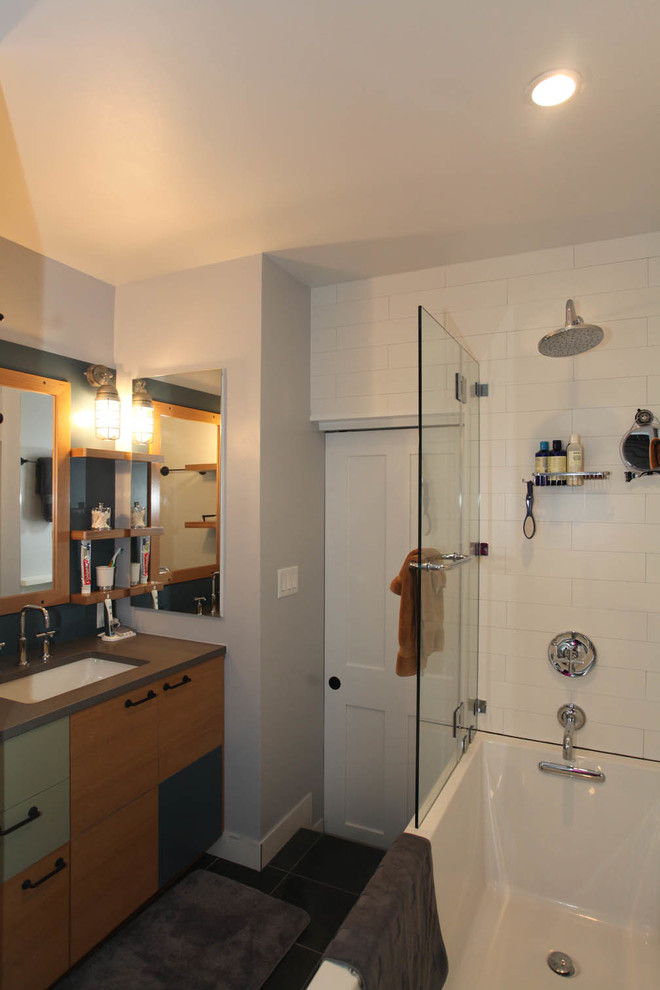 Cette image montre une petite salle de bain principale design en bois clair avec un placard à porte plane, un plan de toilette en quartz modifié, un combiné douche/baignoire, WC à poser, un carrelage blanc, des carreaux de céramique, un mur gris, un sol en ardoise, une baignoire en alcôve et un lavabo encastré.
