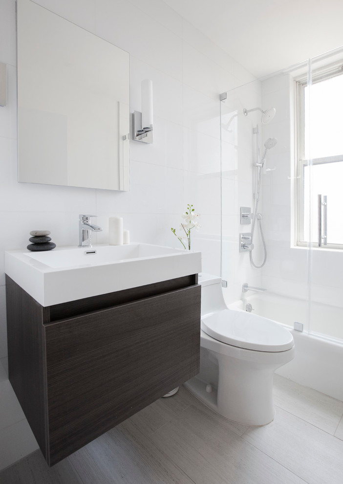 This is an example of a contemporary bathroom in New York with a console sink, flat-panel cabinets, grey cabinets, an alcove bath, a shower/bath combination and white tiles.