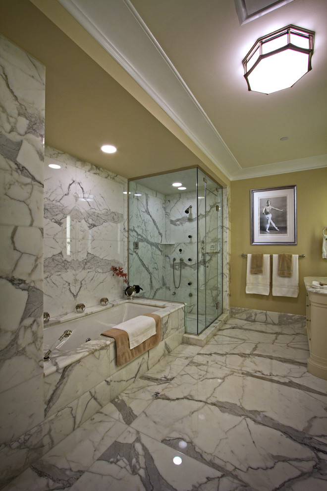 Immagine di una stanza da bagno tradizionale con vasca ad alcova e piastrelle di marmo