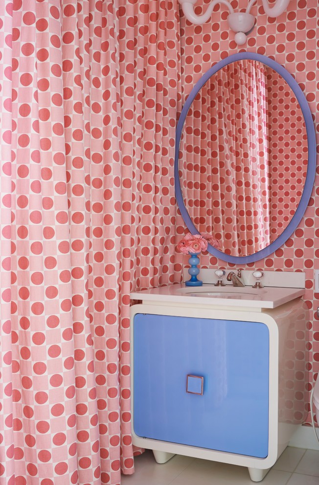 Cette photo montre une salle de bain tendance avec des portes de placard bleues et un mur multicolore.