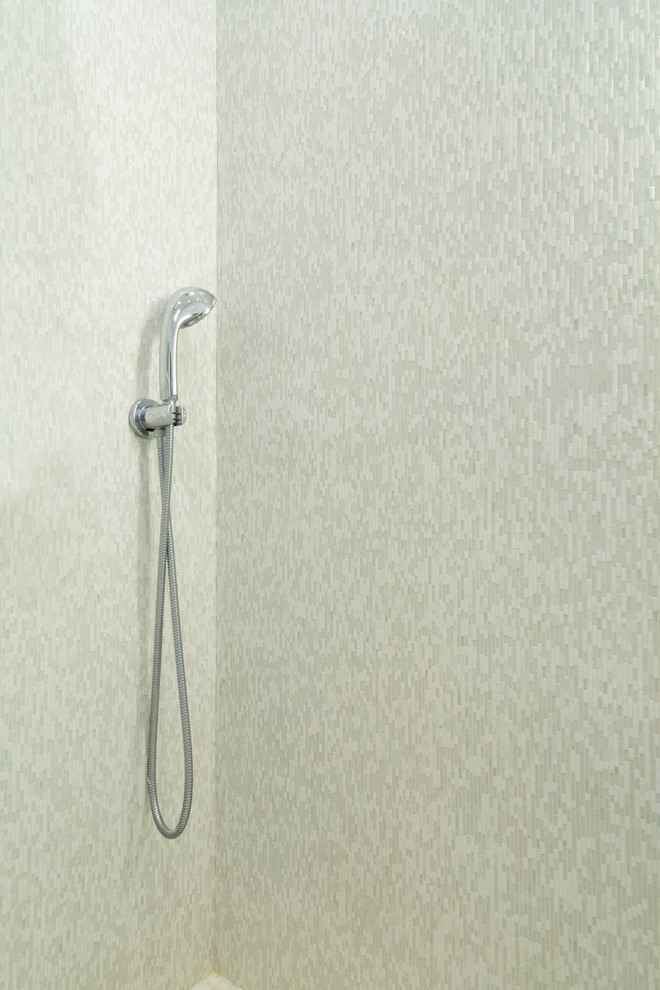 Foto på ett litet funkis badrum med dusch, med ett undermonterad handfat, släta luckor, vita skåp, marmorbänkskiva, en hörndusch, en toalettstol med hel cisternkåpa, grå kakel, glaskakel, grå väggar och marmorgolv