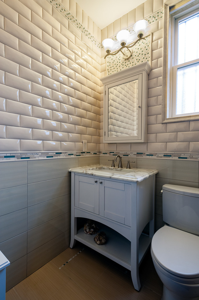 Inspiration för mellanstora klassiska badrum med dusch, med ett undermonterad handfat, skåp i shakerstil, vita skåp, marmorbänkskiva, en toalettstol med separat cisternkåpa, grå kakel, glaskakel, beige väggar och klinkergolv i keramik