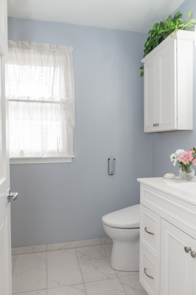Идея дизайна: маленькая главная ванная комната в классическом стиле с фасадами с выступающей филенкой, белыми фасадами, душем в нише, раздельным унитазом, белой плиткой, синими стенами, полом из керамической плитки, монолитной раковиной, столешницей из оникса, белым полом, белой столешницей, сиденьем для душа, тумбой под одну раковину и встроенной тумбой для на участке и в саду
