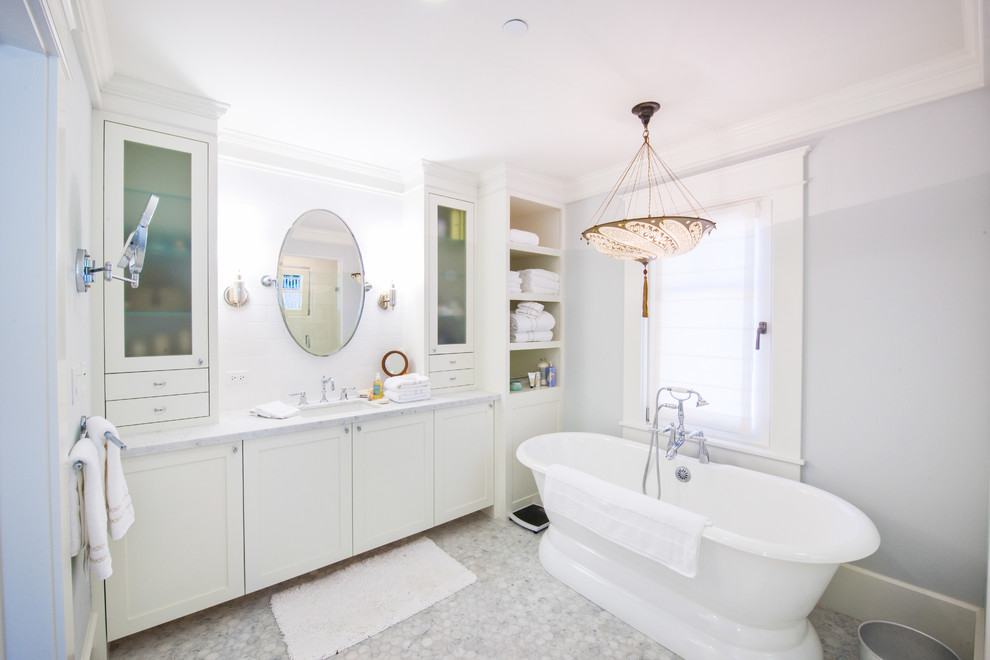 Inspiration for a mid-sized contemporary master subway tile marble floor and white floor bathroom remodel in San Francisco with an undermount sink, white cabinets, white walls, a two-piece toilet, marble countertops, a hinged shower door and glass-front cabinets