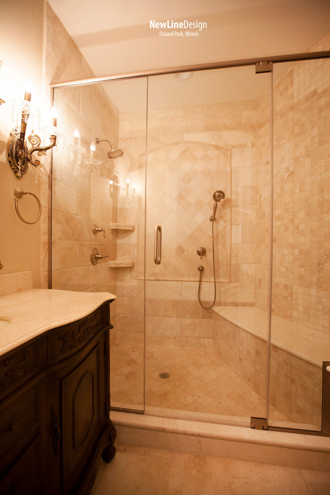 Elegant beige tile and stone tile bathroom photo in Chicago with an undermount sink, raised-panel cabinets, beige cabinets, marble countertops and a two-piece toilet