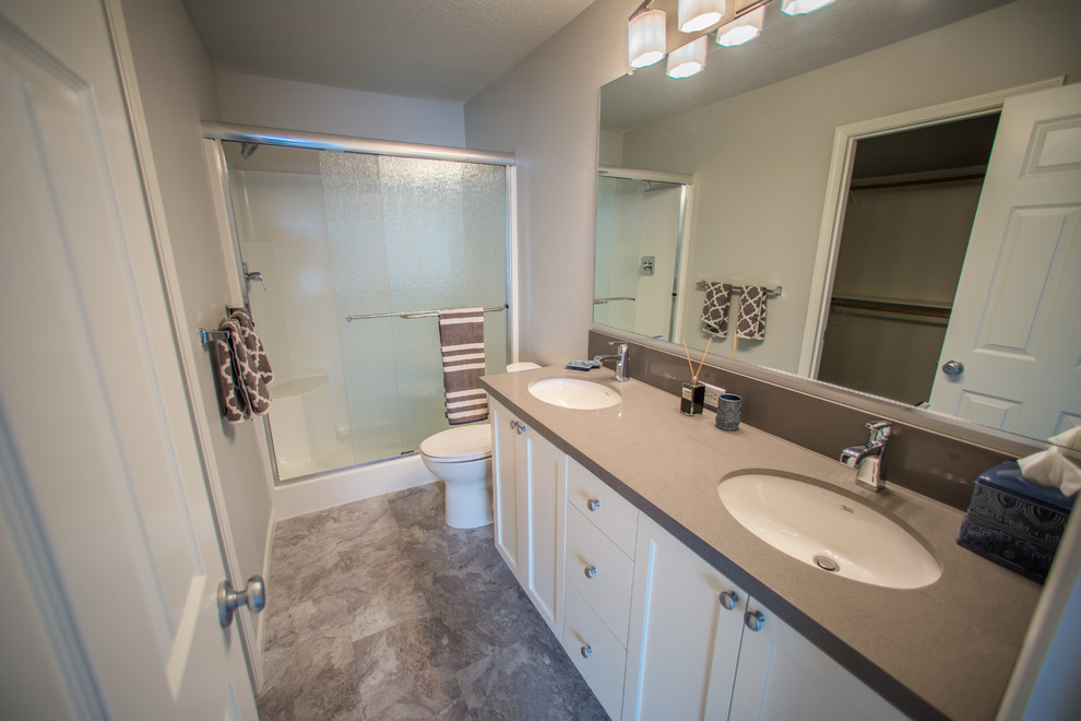 Inspiration for a small transitional 3/4 laminate floor and gray floor bathroom remodel in Portland with shaker cabinets, white cabinets, a two-piece toilet, gray walls, an undermount sink and granite countertops