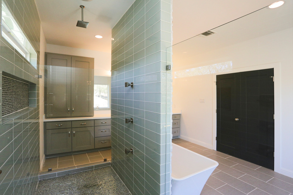 Large contemporary ensuite bathroom in Houston with a built-in sink, recessed-panel cabinets, grey cabinets, marble worktops, a freestanding bath, a walk-in shower, a one-piece toilet, green tiles, glass tiles, white walls and mosaic tile flooring.