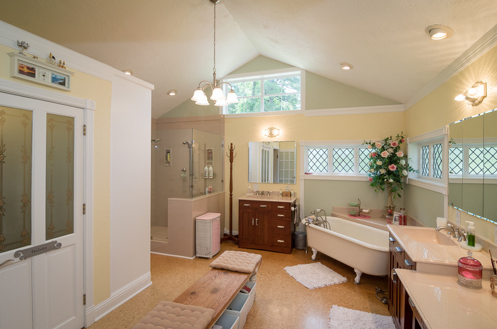 Cette image montre une salle de bain principale rustique en bois brun avec un lavabo intégré, un placard à porte shaker, un plan de toilette en quartz modifié, une baignoire sur pieds, une douche double, WC à poser, un carrelage beige, un mur jaune et un sol en liège.