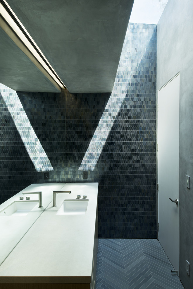 Réalisation d'une salle de bain design avec un lavabo encastré, un placard à porte plane, un carrelage noir, mosaïque et un mur gris.