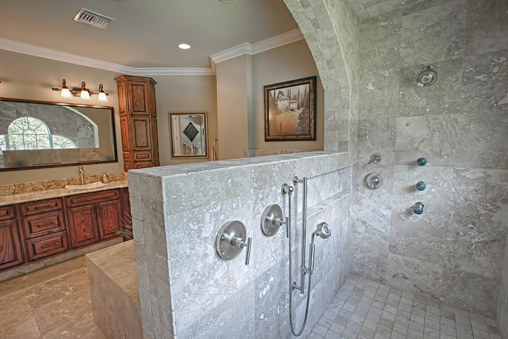 Example of a mid-sized classic master beige tile and porcelain tile travertine floor bathroom design in Orlando with recessed-panel cabinets, dark wood cabinets, a one-piece toilet, beige walls, an undermount sink and granite countertops