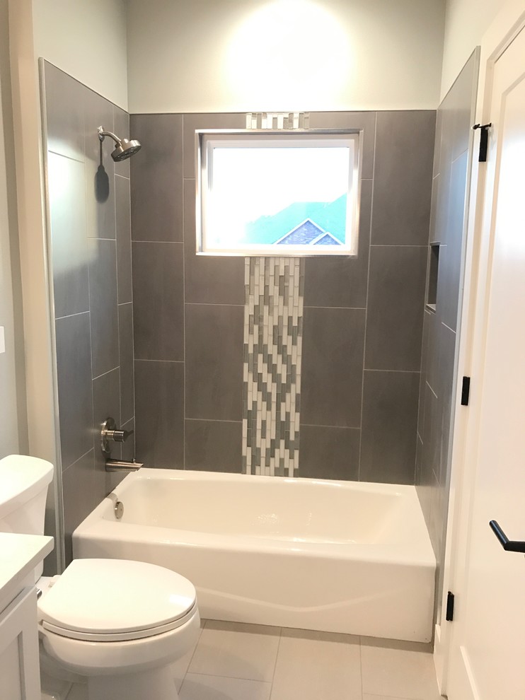 Idéer för ett mellanstort modernt vit badrum med dusch, med skåp i shakerstil, vita skåp, ett badkar i en alkov, en dusch/badkar-kombination, en toalettstol med separat cisternkåpa, grå kakel, porslinskakel, grå väggar, klinkergolv i porslin, ett undermonterad handfat, bänkskiva i akrylsten och grått golv