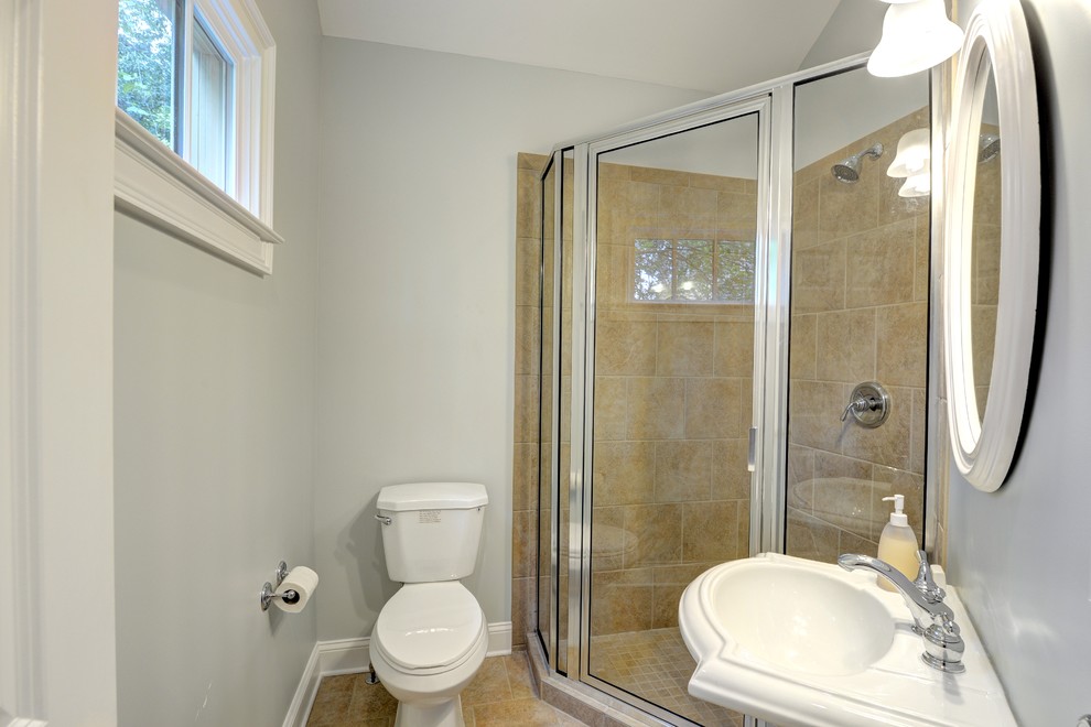 Immagine di una piccola stanza da bagno con doccia stile americano con lavabo a colonna, doccia ad angolo, WC a due pezzi, piastrelle beige, piastrelle di cemento, pareti grigie e pavimento con piastrelle in ceramica