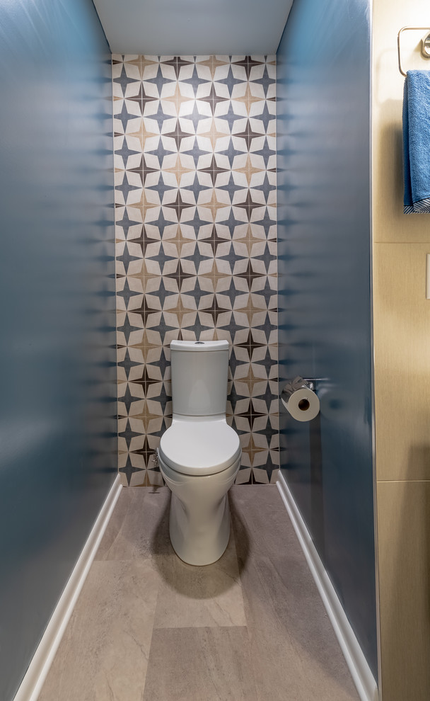 Design ideas for a small contemporary cloakroom in Milwaukee with freestanding cabinets, brown cabinets, a two-piece toilet, multi-coloured tiles, porcelain tiles, multi-coloured walls, porcelain flooring, an integrated sink, solid surface worktops, grey floors and white worktops.