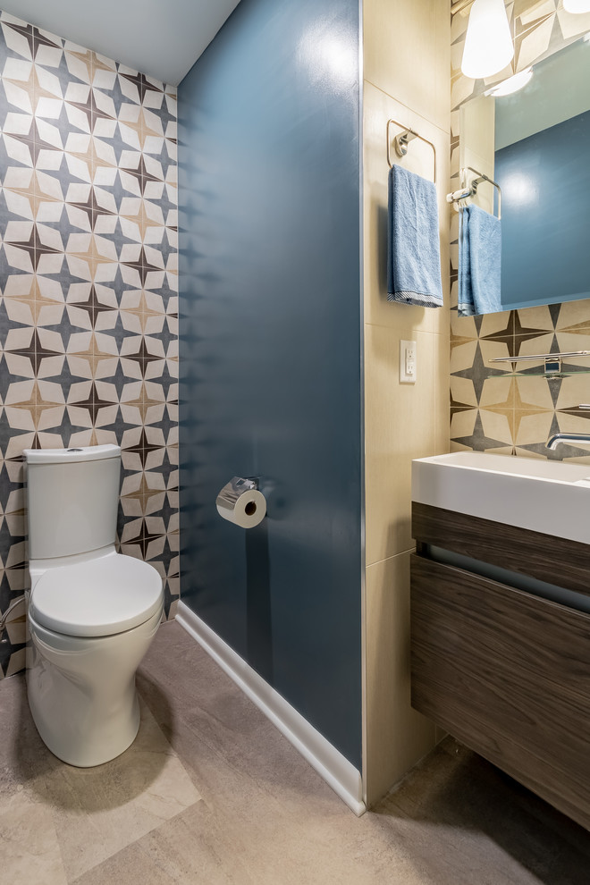 Small modern shower room bathroom in Milwaukee with freestanding cabinets, brown cabinets, a two-piece toilet, multi-coloured tiles, porcelain tiles, multi-coloured walls, porcelain flooring, an integrated sink, solid surface worktops, grey floors and white worktops.