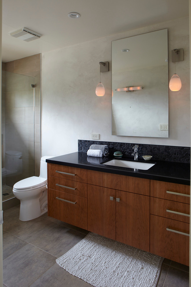 Свежая идея для дизайна: главная ванная комната среднего размера в современном стиле с плоскими фасадами, темными деревянными фасадами, душем в нише, унитазом-моноблоком, бежевыми стенами, полом из керамогранита, врезной раковиной, серым полом и душем с распашными дверями - отличное фото интерьера