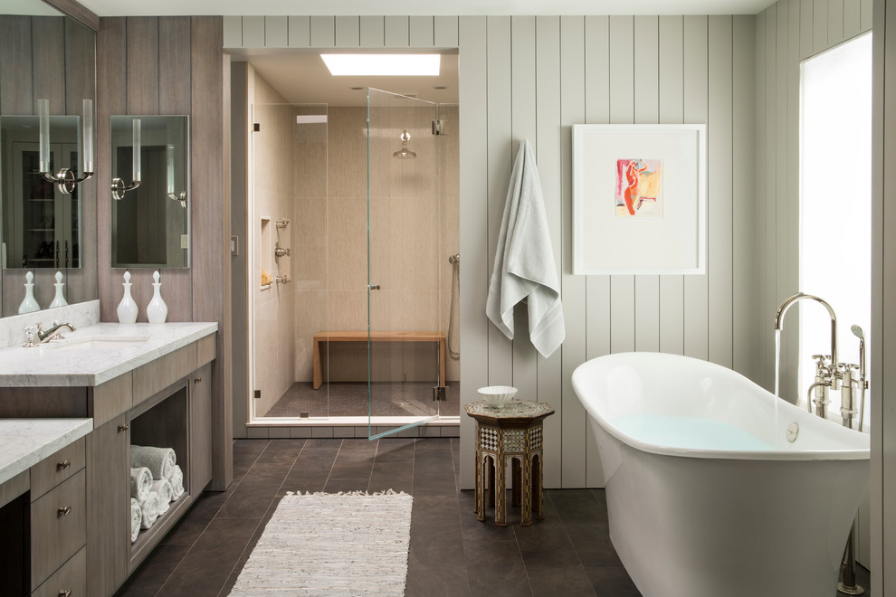This is an example of a large traditional bathroom in San Francisco with a submerged sink, flat-panel cabinets, dark wood cabinets, a freestanding bath, an alcove shower, beige tiles, white walls and brown floors.
