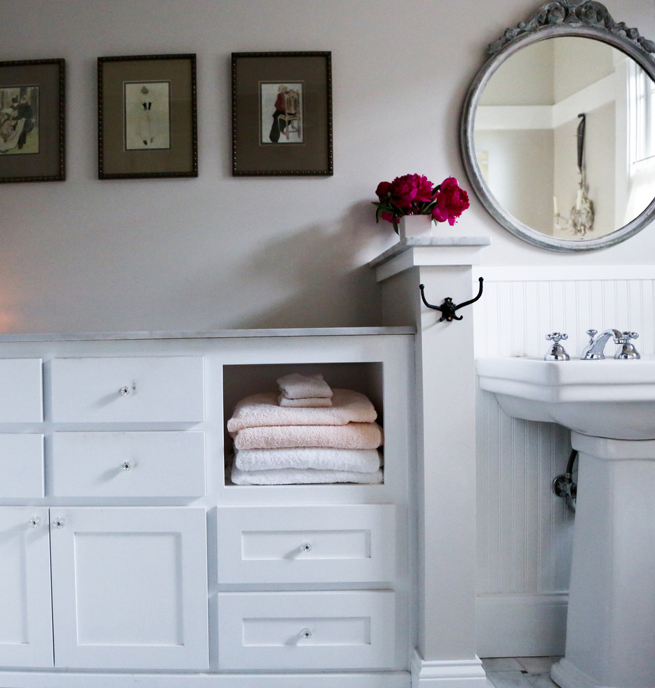 Inspiration för små klassiska badrum, med släta luckor, vita skåp, en toalettstol med separat cisternkåpa, vita väggar, klinkergolv i keramik, ett piedestal handfat, marmorbänkskiva och vitt golv