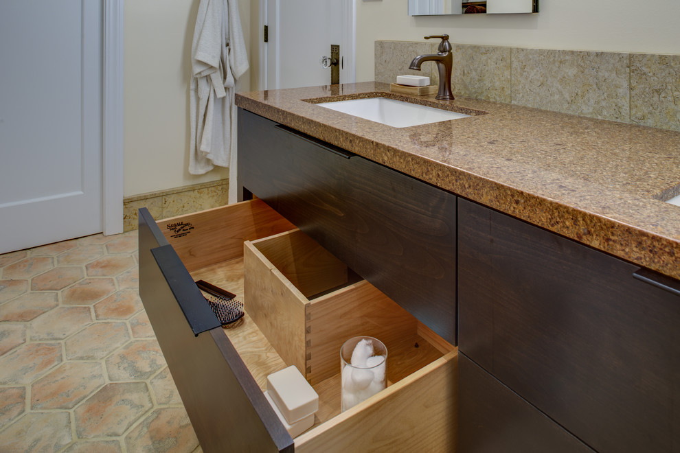 This is an example of a medium sized mediterranean ensuite bathroom in San Francisco with a submerged sink, dark wood cabinets, engineered stone worktops, an alcove shower, a wall mounted toilet, brown tiles, stone tiles, beige walls, concrete flooring, flat-panel cabinets, an open shower, brown worktops, a wall niche, an enclosed toilet, double sinks and a built in vanity unit.