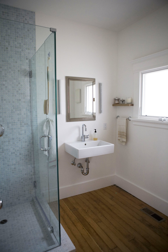 Esempio di una piccola stanza da bagno contemporanea con lavabo sospeso, doccia ad angolo, piastrelle blu, piastrelle in ceramica, pareti bianche e parquet chiaro