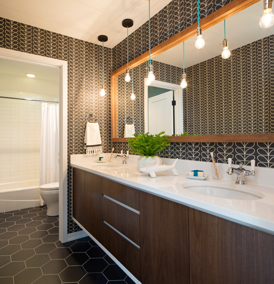 Trendy black floor, double-sink and wallpaper bathroom photo in Minneapolis with flat-panel cabinets, dark wood cabinets, black walls, an undermount sink and white countertops