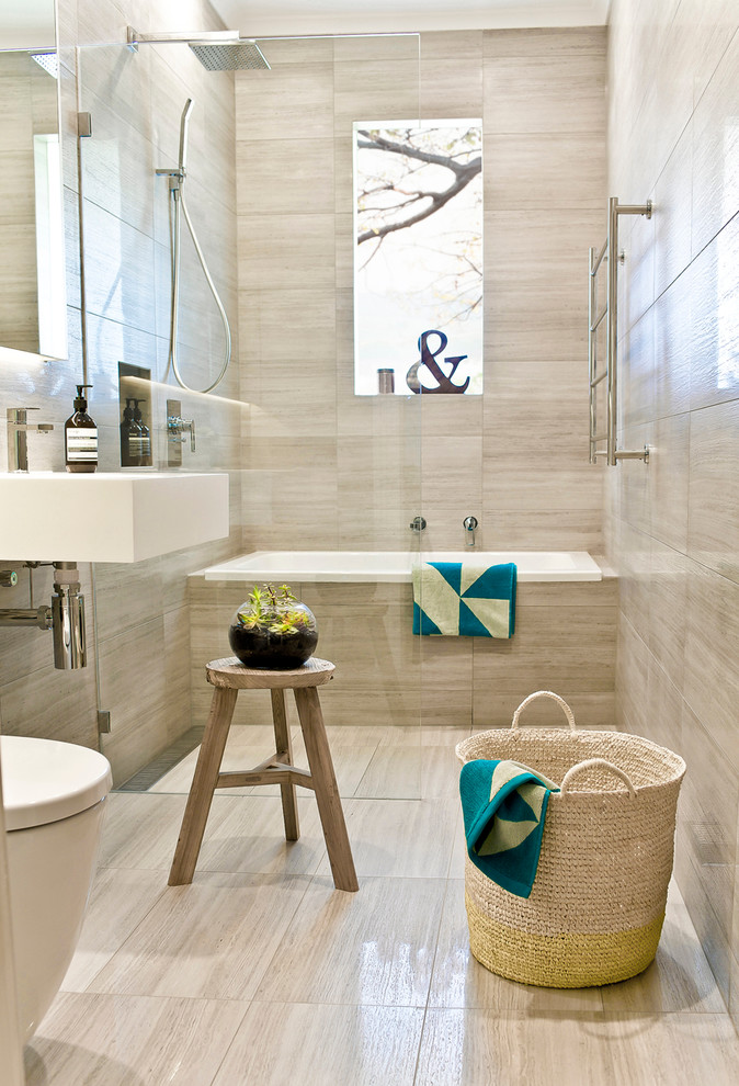 メルボルンにある中くらいなトラディショナルスタイルのおしゃれなお風呂の窓 (アルコーブ型浴槽、シャワー付き浴槽	、ベージュのタイル、壁付け型シンク、トラバーチンタイル) の写真