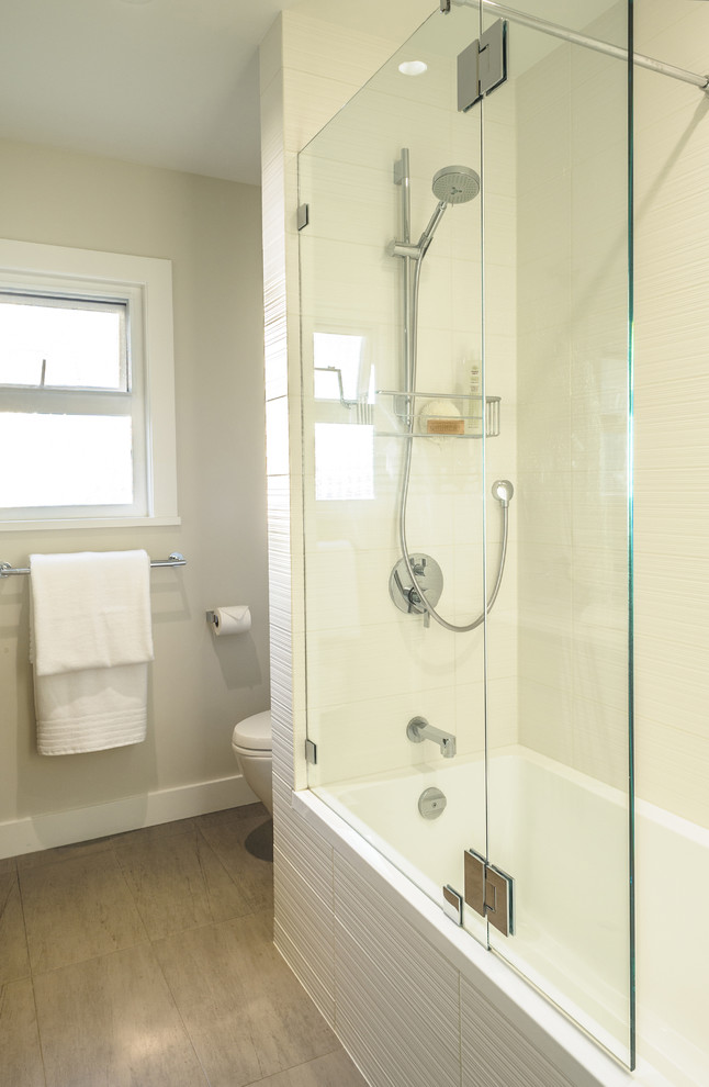 Cette photo montre une salle d'eau tendance en bois brun de taille moyenne avec un placard à porte plane, un combiné douche/baignoire, WC séparés, un carrelage blanc, un mur beige, un sol en ardoise, un lavabo encastré et un plan de toilette en surface solide.