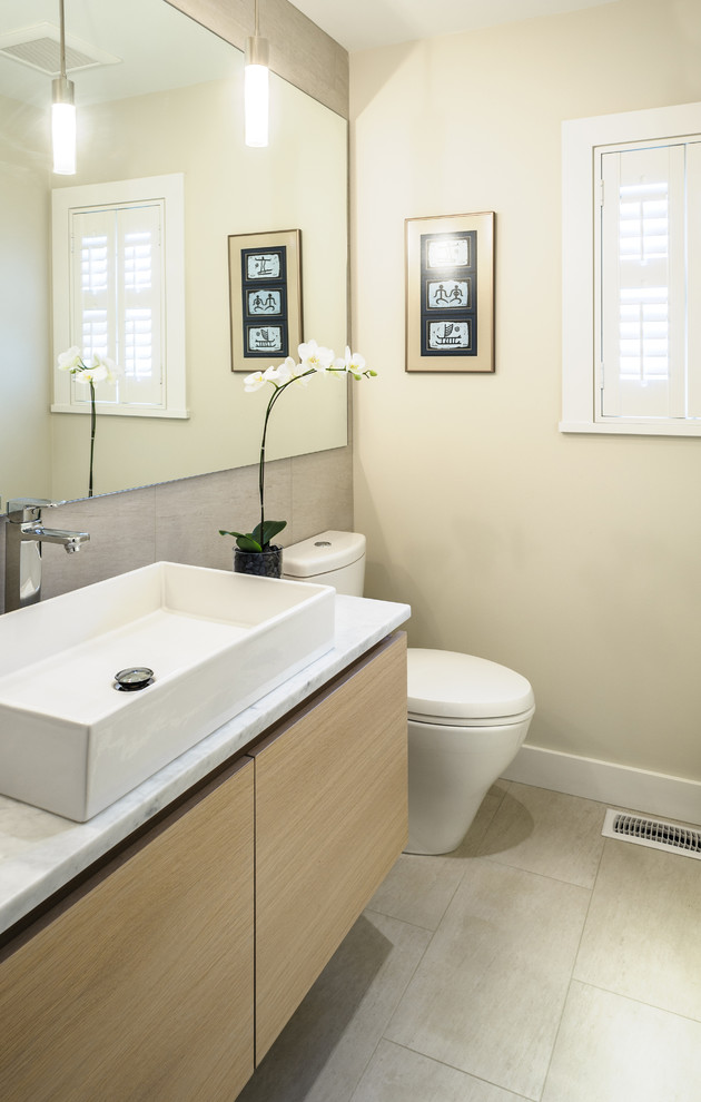 На фото: ванная комната среднего размера в современном стиле с плоскими фасадами, светлыми деревянными фасадами, душем в нише, раздельным унитазом, серой плиткой, белой плиткой, керамогранитной плиткой, полом из сланца, душевой кабиной, врезной раковиной, мраморной столешницей и бежевыми стенами