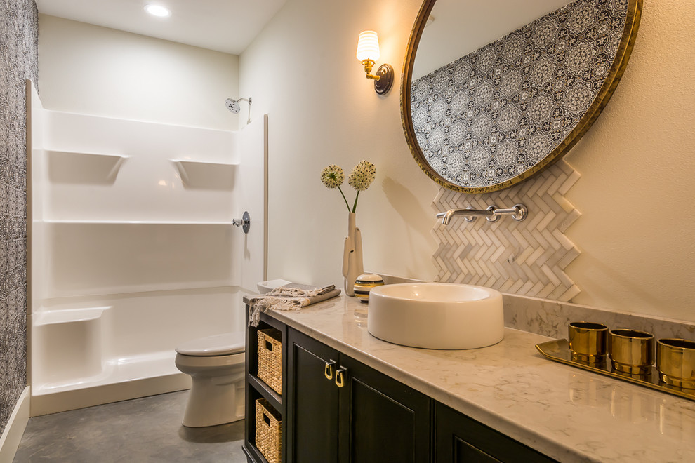 Inspiration for a mid-sized transitional master beige tile and stone tile concrete floor doorless shower remodel in Cedar Rapids with shaker cabinets, brown cabinets, a one-piece toilet, gray walls, a vessel sink and granite countertops