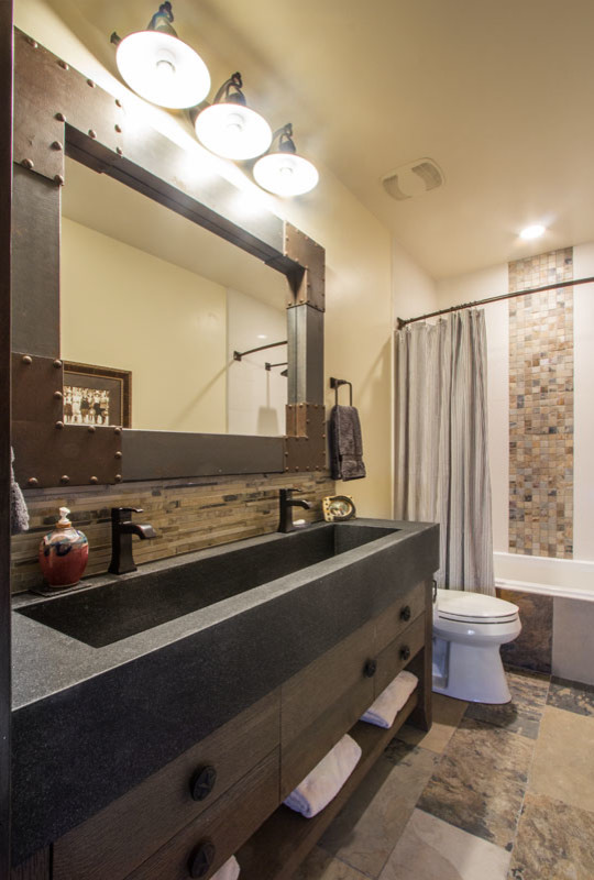 ソルトレイクシティにある中くらいなトランジショナルスタイルのおしゃれなバスルーム (浴槽なし) (フラットパネル扉のキャビネット、濃色木目調キャビネット、アルコーブ型浴槽、シャワー付き浴槽	、分離型トイレ、茶色いタイル、ボーダータイル、ベージュの壁、セラミックタイルの床、一体型シンク、コンクリートの洗面台) の写真
