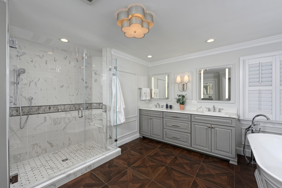 Inspiration for a timeless white tile and marble tile wood-look tile floor, brown floor and double-sink bathroom remodel in DC Metro with furniture-like cabinets, gray cabinets, a two-piece toilet, gray walls, an undermount sink, quartz countertops, a hinged shower door, white countertops and a freestanding vanity