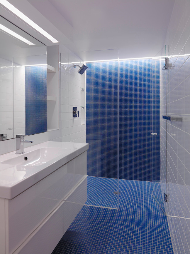 Стильный дизайн: ванная комната в современном стиле с подвесной раковиной, плоскими фасадами, унитазом-моноблоком, синей плиткой и белыми стенами - последний тренд