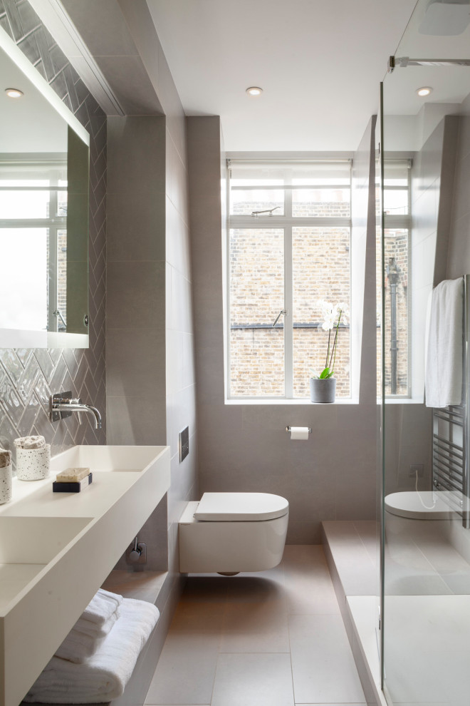 На фото: серо-белая ванная комната среднего размера со стиральной машиной в современном стиле с плоскими фасадами, белыми фасадами, открытым душем, унитазом-моноблоком, серой плиткой, керамогранитной плиткой, серыми стенами, полом из керамогранита, душевой кабиной, подвесной раковиной, серым полом, открытым душем, тумбой под две раковины и подвесной тумбой с