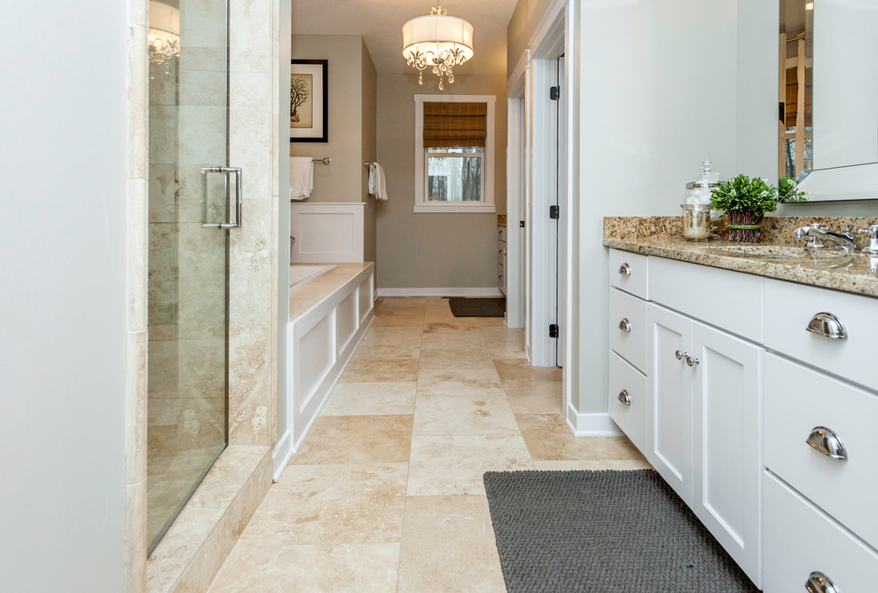Inspiration for a mid-sized craftsman master beige tile and stone slab travertine floor bathroom remodel in Other with an undermount sink, flat-panel cabinets, white cabinets, granite countertops, a one-piece toilet and gray walls