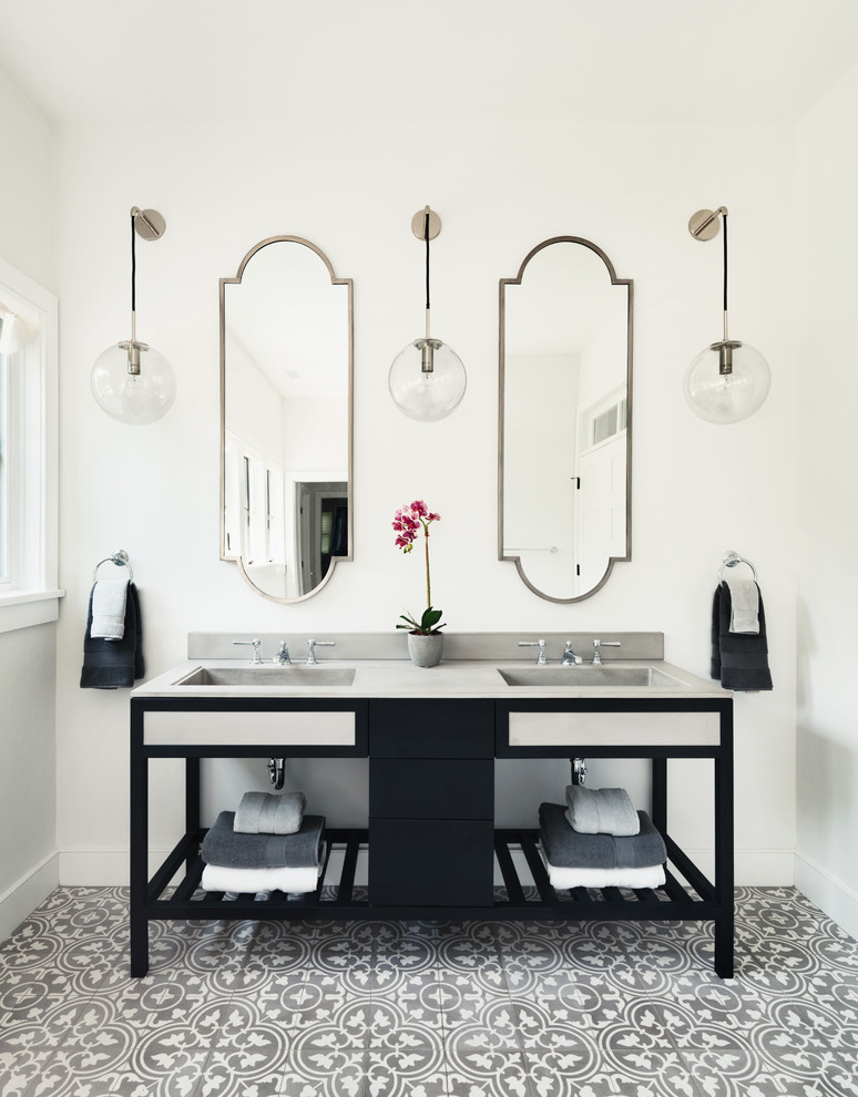 Modelo de cuarto de baño principal tradicional renovado con puertas de armario negras, paredes blancas, suelo de azulejos de cemento, lavabo integrado, encimera de esteatita y armarios abiertos
