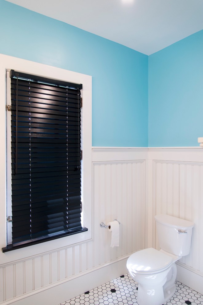 Cette image montre une grande salle de bain principale style shabby chic avec un placard à porte shaker, des portes de placard noires, une baignoire en alcôve, un combiné douche/baignoire, un carrelage noir et blanc, des carreaux de porcelaine, un mur bleu, un sol en carrelage de porcelaine, un lavabo intégré et un plan de toilette en quartz modifié.