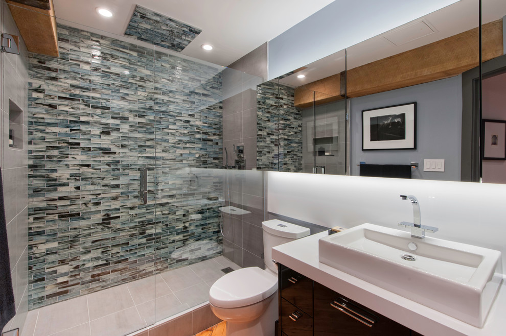 Mittelgroßes Modernes Duschbad mit Aufsatzwaschbecken, flächenbündigen Schrankfronten, dunklen Holzschränken, Duschnische, Toilette mit Aufsatzspülkasten, Glasfliesen, weißer Wandfarbe, Quarzit-Waschtisch und blauen Fliesen in Vancouver