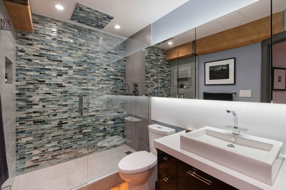 Alcove shower - mid-sized contemporary 3/4 glass tile and blue tile alcove shower idea in Vancouver with a vessel sink, flat-panel cabinets, dark wood cabinets, a one-piece toilet, white walls and quartzite countertops