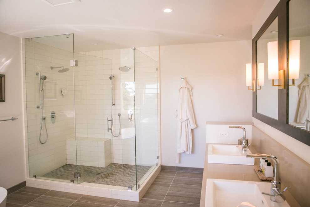 Photo of a large contemporary ensuite bathroom in San Francisco with flat-panel cabinets, dark wood cabinets, a freestanding bath, a corner shower, a one-piece toilet, white tiles, porcelain flooring, a vessel sink, engineered stone worktops, brown floors, a hinged door, ceramic tiles and beige walls.