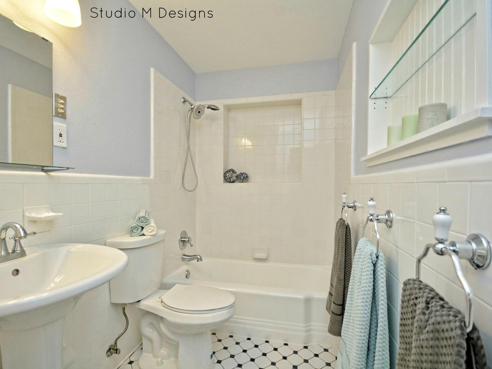 Photo of a medium sized eclectic ensuite bathroom in Austin with a built-in bath, a shower/bath combination, a one-piece toilet, black and white tiles, ceramic tiles, blue walls, porcelain flooring and a pedestal sink.