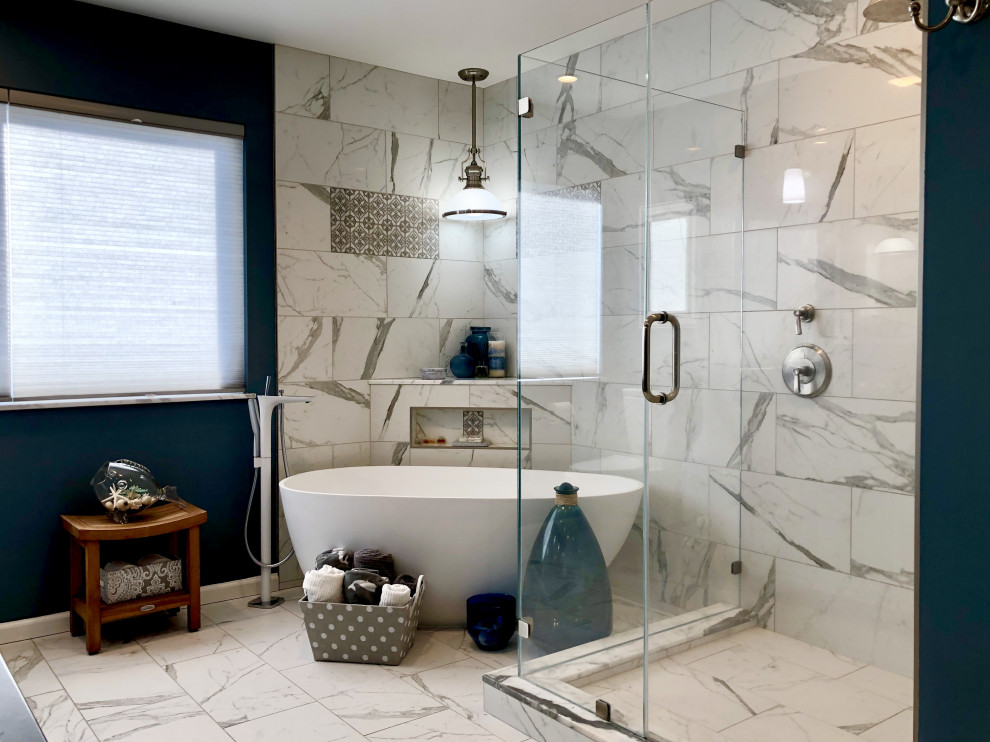 На фото: главная ванная комната среднего размера в стиле фьюжн с фасадами островного типа, серыми фасадами, отдельно стоящей ванной, душем над ванной, унитазом-моноблоком, белой плиткой, керамогранитной плиткой, синими стенами, полом из керамогранита, врезной раковиной, столешницей из оникса, белым полом, душем с распашными дверями и черной столешницей с