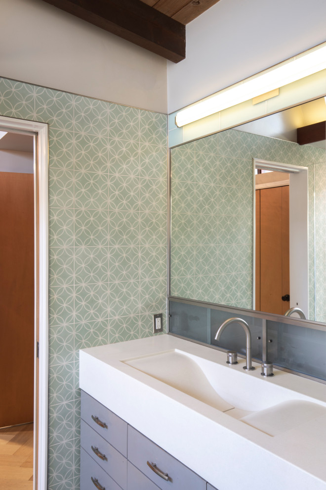 Inredning av ett retro vit vitt en-suite badrum, med släta luckor, grå skåp, ett fristående badkar, våtrum, grön kakel, cementkakel, klinkergolv i småsten, ett väggmonterat handfat, bänkskiva i betong, grått golv och med dusch som är öppen