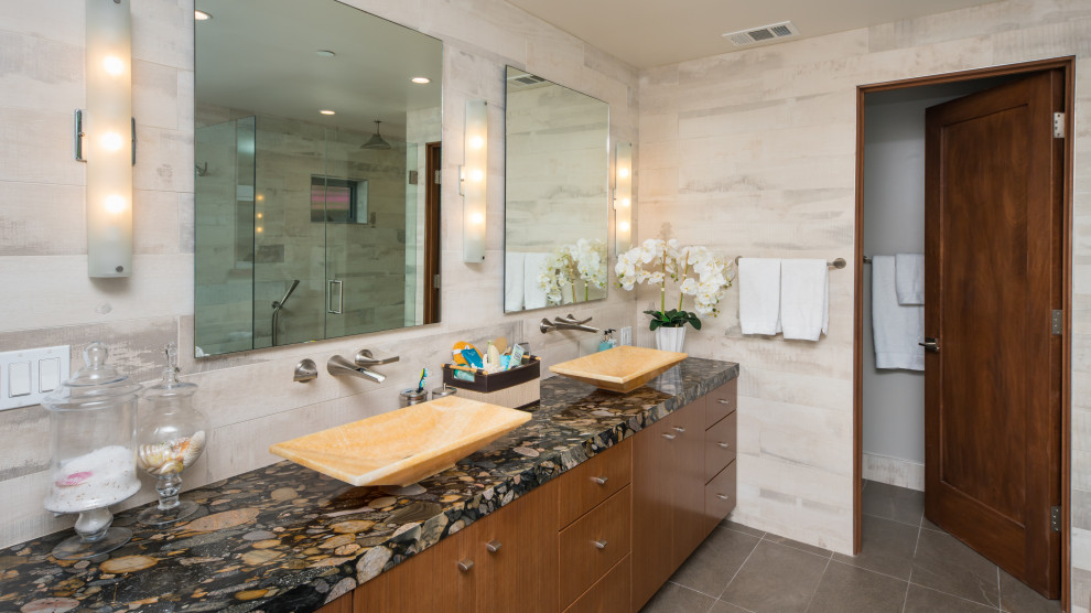 Inspiration for a coastal master beige tile gray floor bathroom remodel in Los Angeles with flat-panel cabinets, medium tone wood cabinets, beige walls, a vessel sink and multicolored countertops