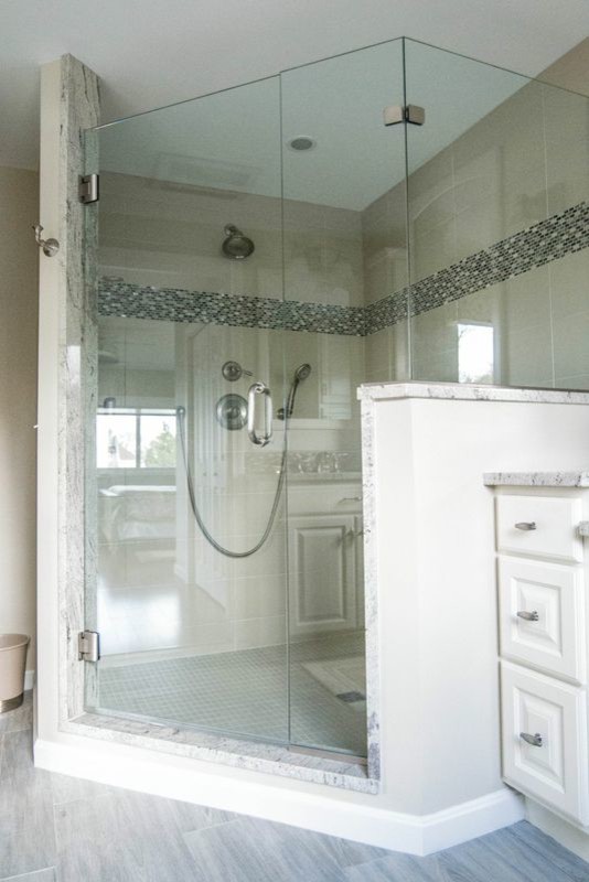 Medium sized nautical ensuite bathroom in Providence with raised-panel cabinets, white cabinets, a corner shower, beige walls, porcelain flooring, a submerged sink, marble worktops, beige floors and a hinged door.