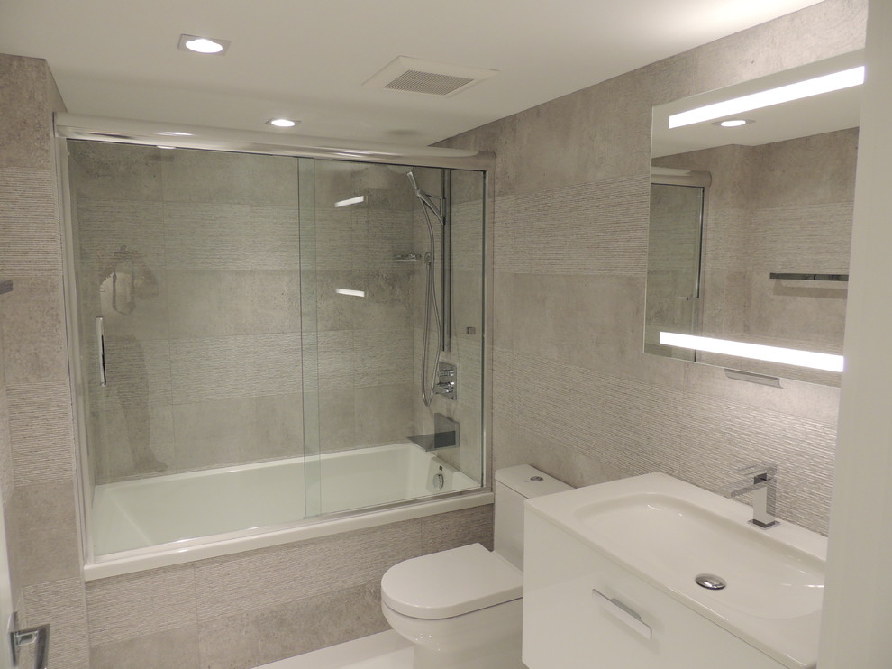 Exempel på ett mellanstort modernt en-suite badrum, med vita skåp, bänkskiva i kvartsit, porslinskakel, ett undermonterad handfat, släta luckor, ett badkar i en alkov, en dusch/badkar-kombination, en toalettstol med hel cisternkåpa, vit kakel, vita väggar och klinkergolv i porslin