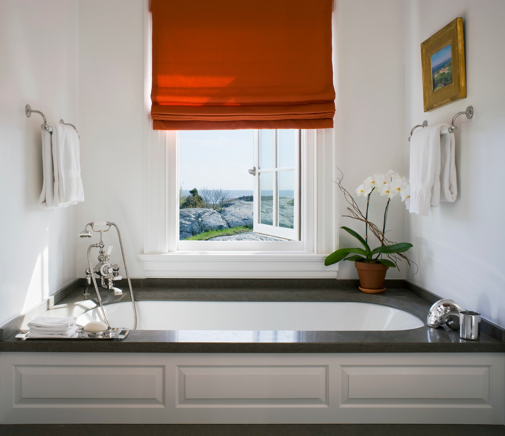 Cette image montre une salle de bain traditionnelle avec une baignoire encastrée et un mur blanc.